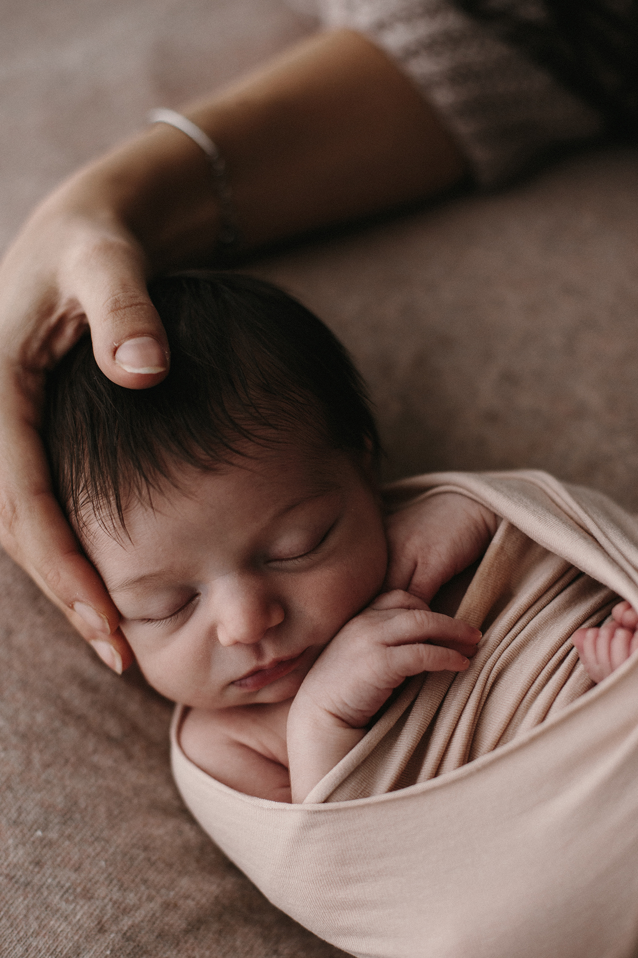 neonato dorme tra lenzuola marroni