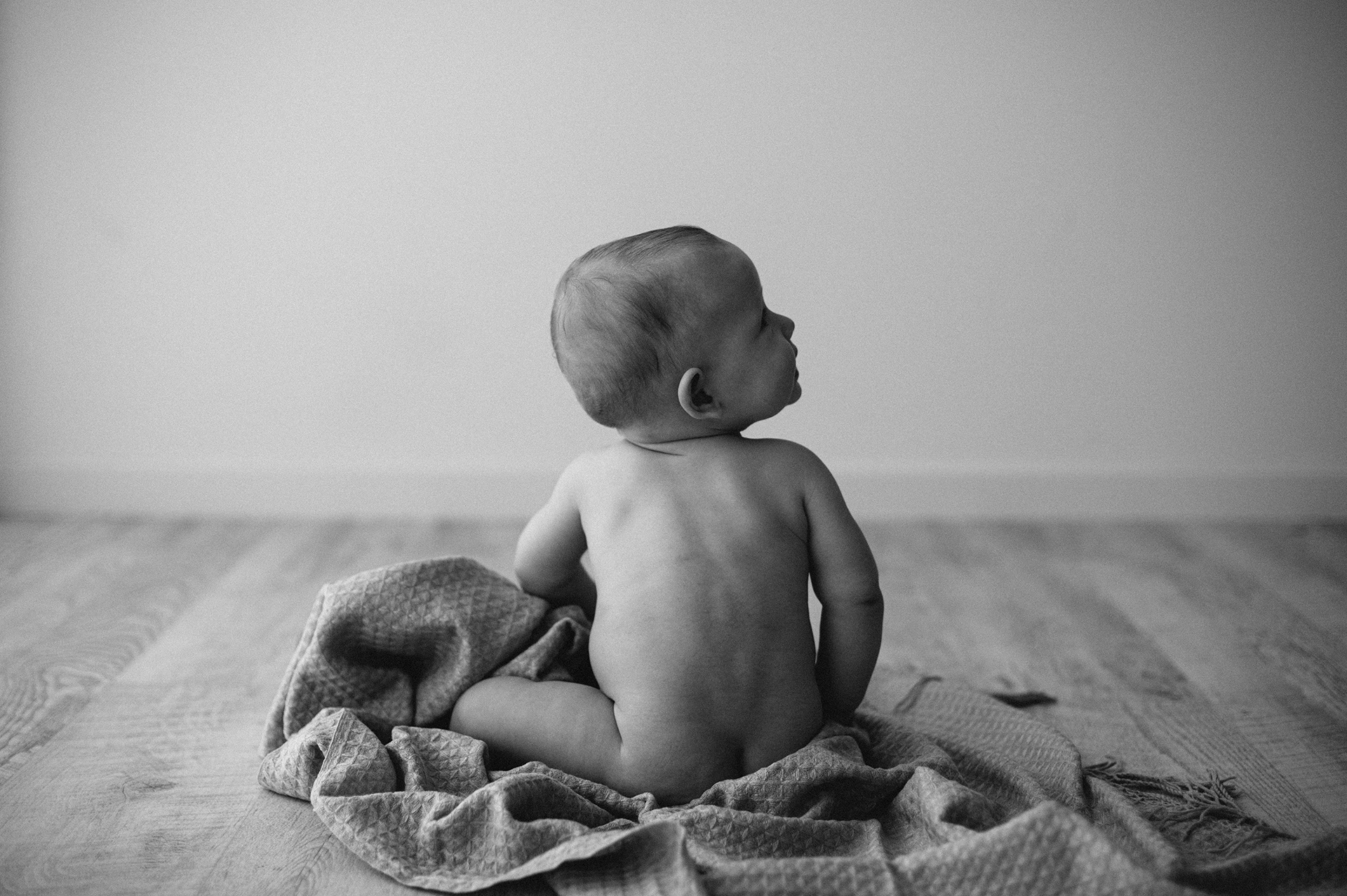 bambino seduto di spalle guarda in alto