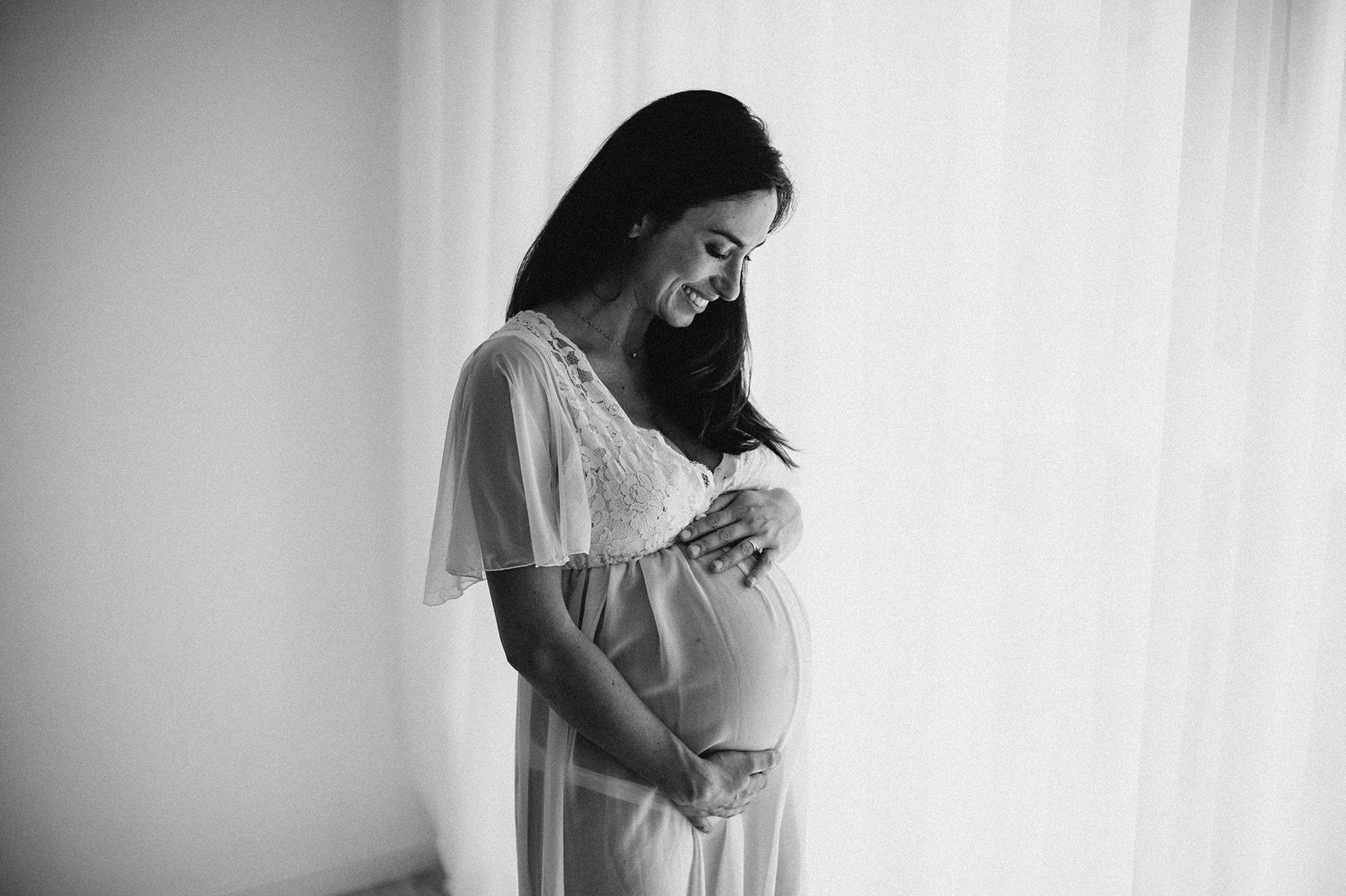 donna gravida sorride guardando la sua pancia