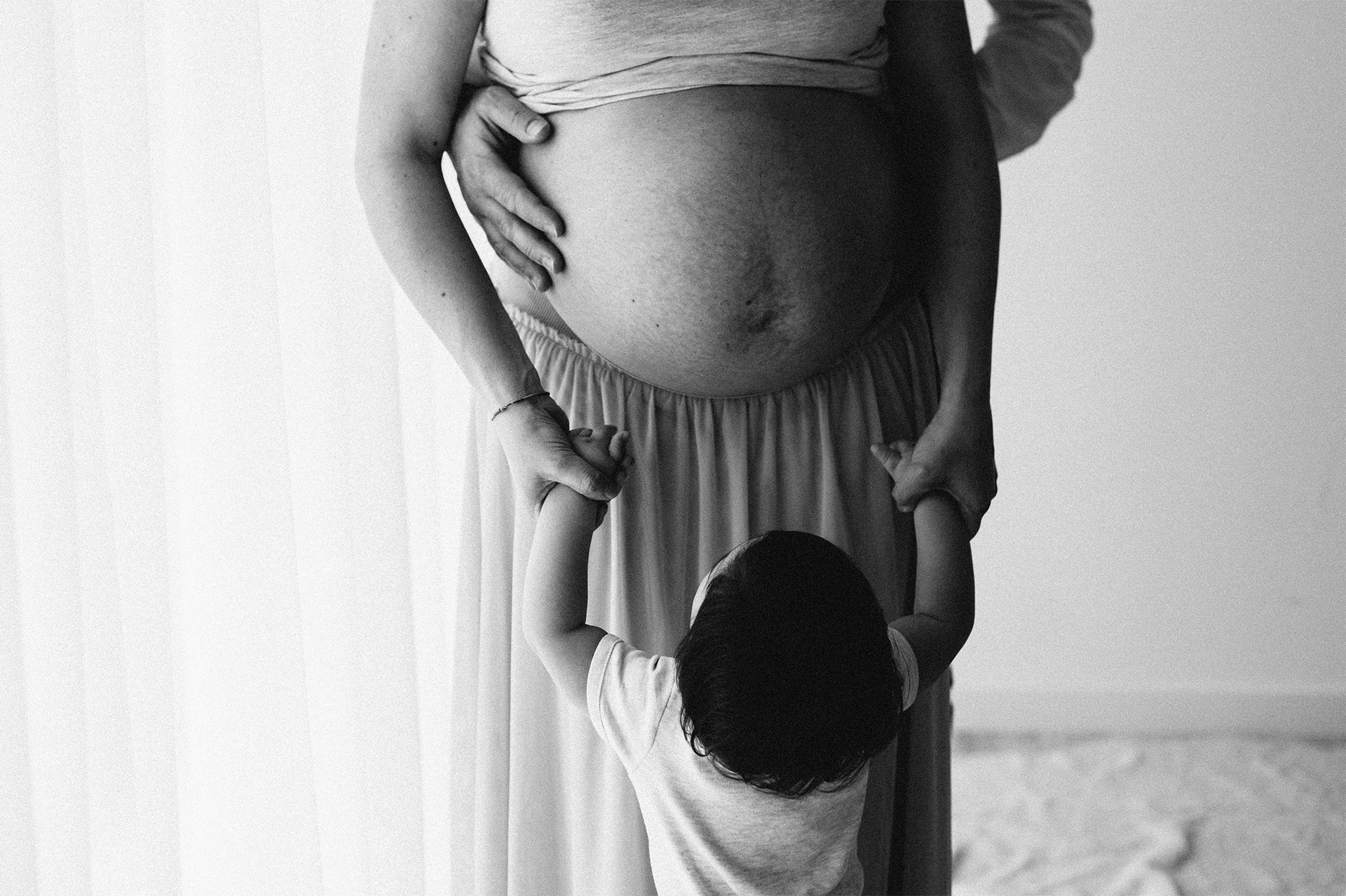 primo figlio guarda il pancione della mamma