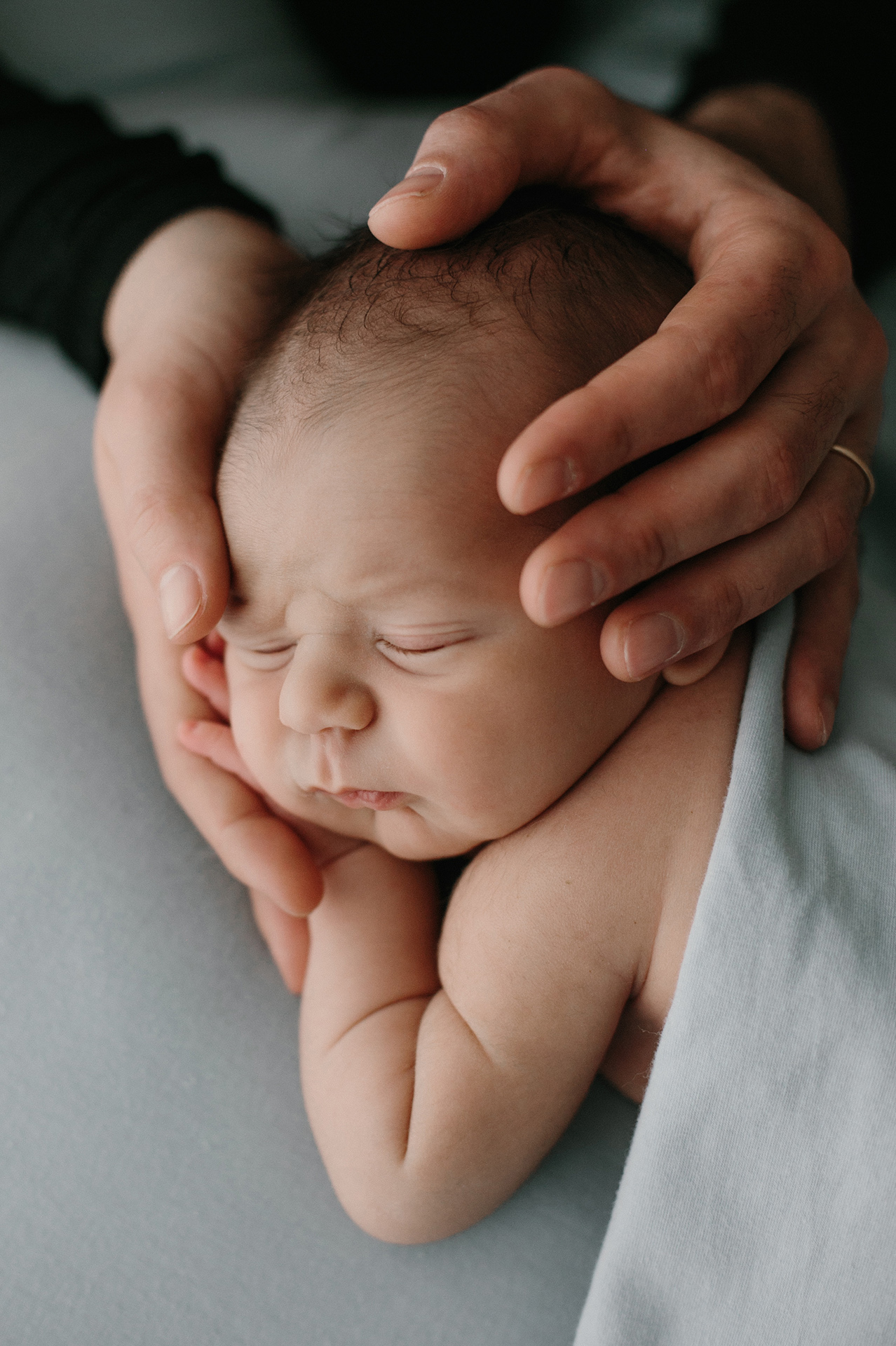 mamma sorregge la testa del neonato dormiente