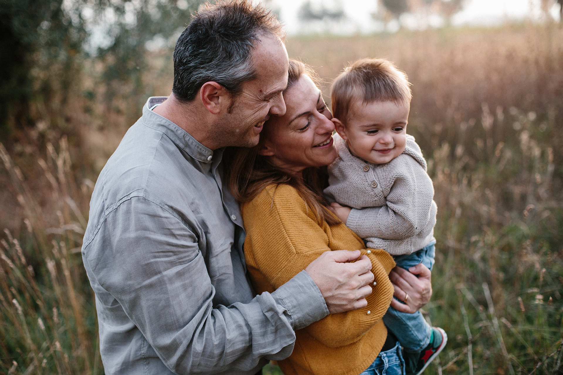 famiglia si abbraccia tra l'erba alta